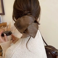 Brown faux leather bow scrunchie on a ponytail for a stylish autumn hair look - Brown