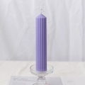 Purple cylindrical scented candle with vertical ridges on a glass candle holder - Striped Pointed Top 4x15cm