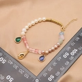 Elegant pearl bracelet with colorful gemstone charms and golden seashell pendant detail - Green Conch Blue Bracelet