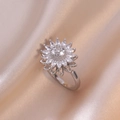 Nahaufnahme des funkelnden silbernen Sonnenblumenrings mit Zirkonia auf beigem Satin - Stahl-Sonnenblumen-Ring (J0034) / Stahlfarben