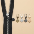 Macro shot of detachable clover-shaped zipper pulls in bronze, silver, and gold finishes - Four-leaf Clover - 5 Mixed Colors