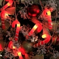 Close-up of candy cane LED lights with warm glow on a festive decorated Christmas tree - Christmas Candy Cane
