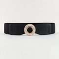 Dettaglio di una cintura elastica nera con fibbia rotonda dorata decorata con strass lucidi - Nero