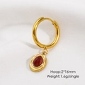 Detailed view of golden hoop earring with a dark red oval gemstone pendant and texture - Red Agate