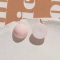 Macro shot of pink glossy and white matte resin heart-shaped DIY craft beads on stone tray - Pink Round