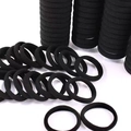 Detailed macro view of seamless black high-elastic hair ties in a bulk set arrangement - Black
