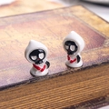 Close-up of two miniature 3D ghost figurines with red heart detail on a vintage book - White Ghost with Knife
