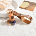 Porte-clés Capybara mignon avec pendentif avion pailleté et dragonne en cuir marron - Capy-Avion