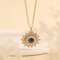Detailed shot of gold plated sunburst Evil Eye pendant with blue iris and sparkling zircon - Light Blue Flower-E5