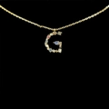 Golden necklace with letter G pendant inlaid with colorful zircon stones on black background - Letter G / Gold