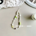 Close-up of handmade beaded phone strap featuring white pearls and green mushroom charms - Ceramic Elephant