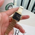 Close-up of a gold square quartz watch with black dial and metal chain strap held by hand - Gold/Black