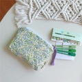 Dettaglio della pochette in tessuto a fiori con nappa viola e chiusura a zip bianca - Floreale verde chiaro e viola