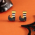 Macro shot of Halloween witch boot earrings with stripes on an orange background - Witch Boots