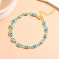 Close-up of golden Evil Eye bracelet with blue enamel beads and adjustable lobster clasp - Light Blue Gold
