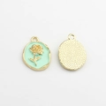 Detail of oval rose charm with mint green enamel inlay and textured golden metal back - Fruit Green