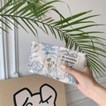 Gedetailleerde close-up van de bloemgeborduurde mini-cosmetische tas in crème-wit - Jacquard Bladeren