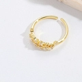 Macro-opname van een gouden druppelring met sprankelende micro-pave zirkonia inleg - Wit Zirkoon Bloem