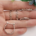 Detailed view of silver crown rings and earring base accessories held on a hand - Platinum Crown Ring Base