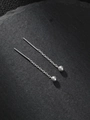 Pendientes de cadena minimalistas en plata con colgantes esféricos sobre fondo de piedra - Plateado