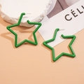 Dettaglio di orecchini a cerchio a stella in acrilico verde su sfondo caldo e minimalista - Verde