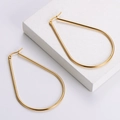 Minimalist titanium steel teardrop hoop earrings with high-polish gold finish on a white stand - Teardrop