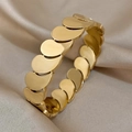 Macro shot of tiered wavy gold bracelet with mirror finish on soft silk fabric - Gold