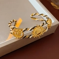 Makro-Detail des Vintage-Webarmbands mit Sonnenblumen- und Rosenrelief-Anhängern - Armreif - Gold - Schwarz