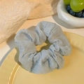 Elegant light blue organza scrunchie with bubble crepe texture on a ceramic plate - Puff Blue