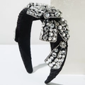 Détail d'un serre-tête large en velours noir avec un grand nœud orné de strass brillants - Noir