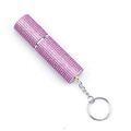 Macro detail of portable pink rhinestone perfume bottle with silver keychain - Pink