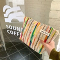 Gros plan d'une pochette en tissu à rayures colorées avec détails de texture tricotée - Grande Trousse de Maquillage