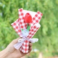 Handgehaltener Strauß mit einer roten Tulpe, rot-weißem Karopapier und Spitzenschleife - Rote Tulpe Rot Gingham