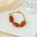 Gold stainless steel link bracelet with amber resin stones on a decorative tray - Stainless Steel Marble Pattern Bracelet / Brown