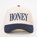 Detailed close-up of HONEY embroidery on a two-tone cotton baseball cap with blue brim - One Size / Cream/Navy Blue