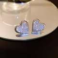 Vue macro de boucles d'oreilles cœur en argent serties de cristaux et gemme rose - Coeur en Zirconium Argenté