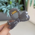 Detail of gray resin bow hair claw clip showing shiny finish and golden metal spring - Light Silver Grey - Small Bowknot