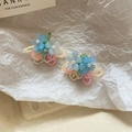 Dettaglio di orecchini a fiore in resina blu con perline colorate e frange lunghe - Perlina con Petalo Blu Traslucido (Perno in Argento)