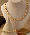 Dettaglio di un set di collana e bracciale a catena a corda dorata su espositori per gioielli - Set catena a fune dorata / Oro