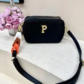 Chique zwarte crossbodytas met textuur, gouden P-logo en kleurrijke riemdetails - Zwart
