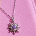 Collana sole in argento con opale viola e zirconi su sfondo di velluto rosa - Collana Opale Viola Tono Acciaio