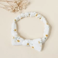 Detail of yellow floral baby headband with a cotton bow and stretchy ruffled texture - Small Yellow Flower