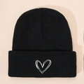 Detailed close-up of white heart embroidery on a black knitted winter beanie hat - Black