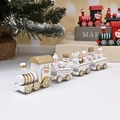 Gros plan d'un petit train de Noël en bois blanc et doré avec figurines festives - Blanc