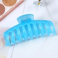 Close-up of a blue hollow-out large claw clip for hair styling on a white background - Jelly Blue