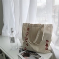 Minimalist cream canvas tote bag with red artistic lettering and dual handles for daily use - Lace-up Style / Beige