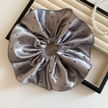 Vue détaillée du grand chouchou en satin argenté à pois noirs posé sur un plateau à bijoux - Chouchou en Satin Gris Argenté à Pois (60#)