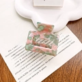 Square acetate hair claw with green pink and orange marble texture on paper tray - Pink & Green