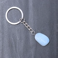 Silver keychain with an irregular natural white moonstone crystal pendant on marble surface - Synthetic Opal