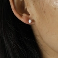 Minimalist white round ball stud earring shown on ear for realistic wear effect - 4mm / White